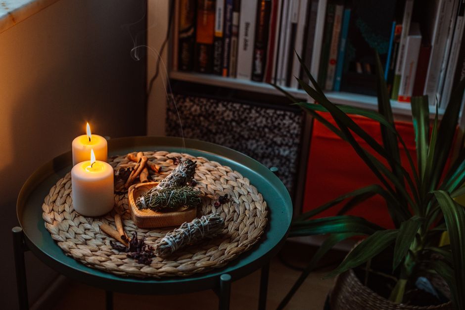 Запалена свещ до книга в уютен ъгъл